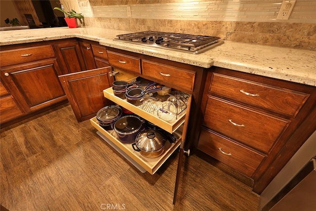 kitchen featuring light stone counters, dark wood-type flooring, and stainless steel gas cooktop