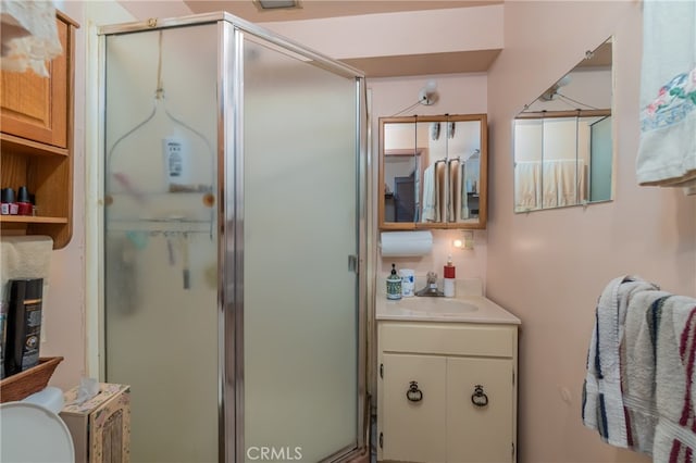 bathroom featuring vanity, toilet, and a shower with shower door