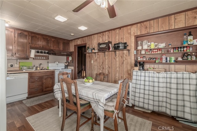 dining room with wood walls, dark hardwood / wood-style floors, ceiling fan, and sink