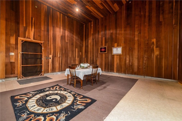 dining room featuring wood ceiling and wood walls