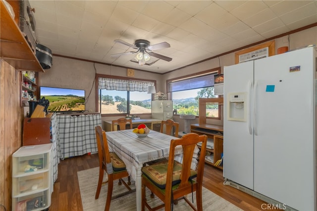 dining room featuring wood-type flooring, crown molding, and ceiling fan