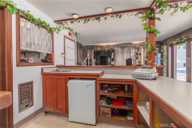 kitchen with heating unit, sink, and white fridge