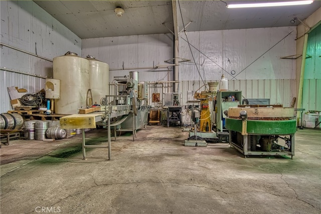 misc room with a workshop area, a towering ceiling, and concrete flooring