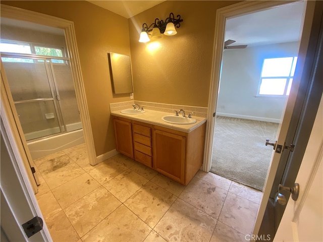 bathroom with shower / bath combination with glass door, a healthy amount of sunlight, vanity, and ceiling fan