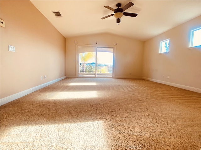 carpeted empty room with lofted ceiling, ceiling fan, and plenty of natural light