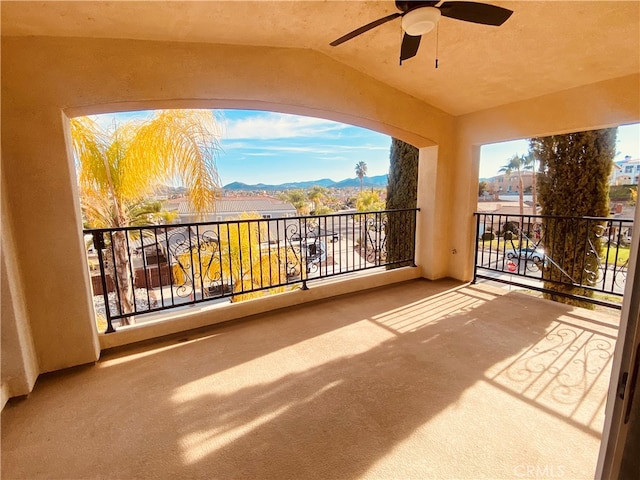 balcony featuring a mountain view and ceiling fan