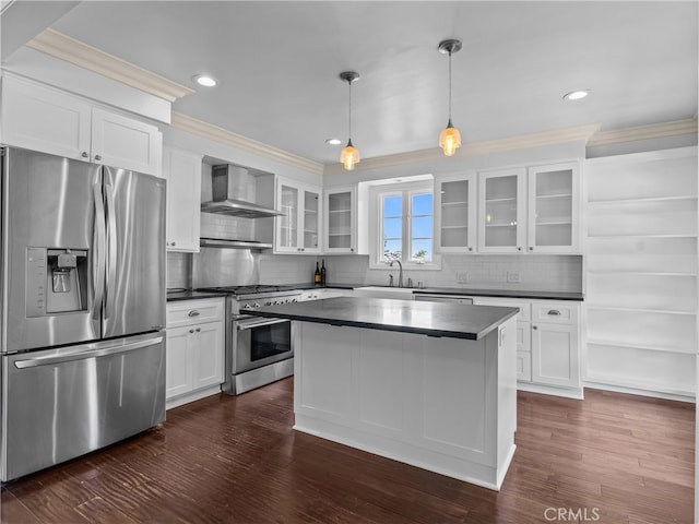 kitchen with white cabinets, wall chimney exhaust hood, pendant lighting, stainless steel appliances, and dark hardwood / wood-style floors