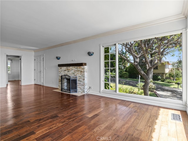 unfurnished living room featuring crown molding, a stone fireplace, and dark hardwood / wood-style flooring