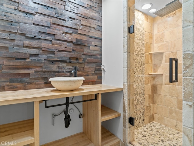 bathroom featuring hardwood / wood-style flooring, a shower with shower door, and sink