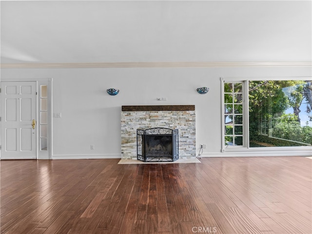 unfurnished living room featuring wood-type flooring, a fireplace, and crown molding