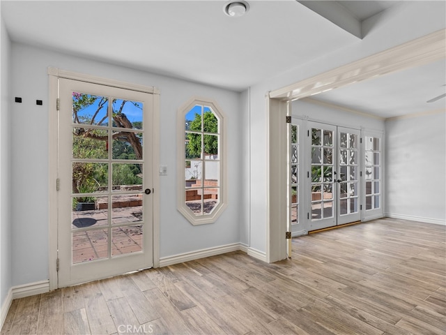 entryway featuring french doors, beamed ceiling, light hardwood / wood-style floors, and a healthy amount of sunlight