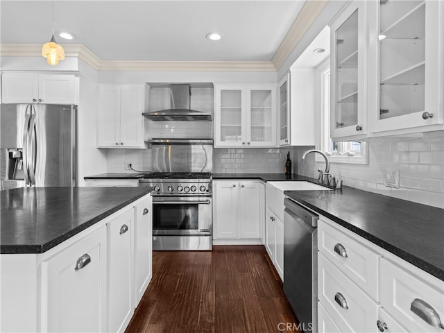 kitchen featuring hanging light fixtures, wall chimney exhaust hood, white cabinetry, appliances with stainless steel finishes, and dark hardwood / wood-style flooring