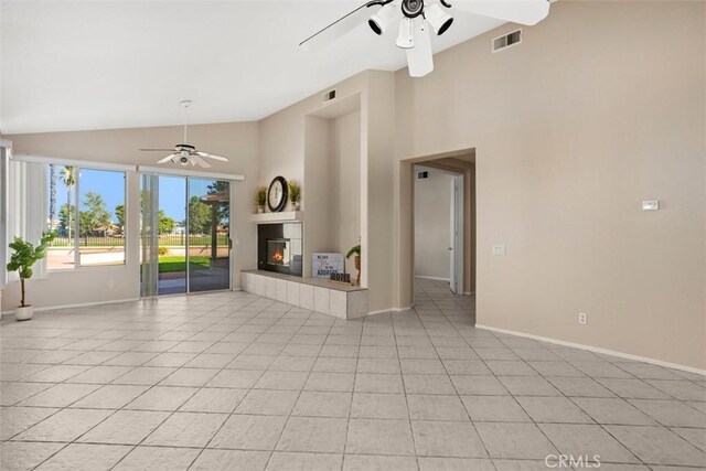 unfurnished living room featuring light tile patterned flooring and high vaulted ceiling