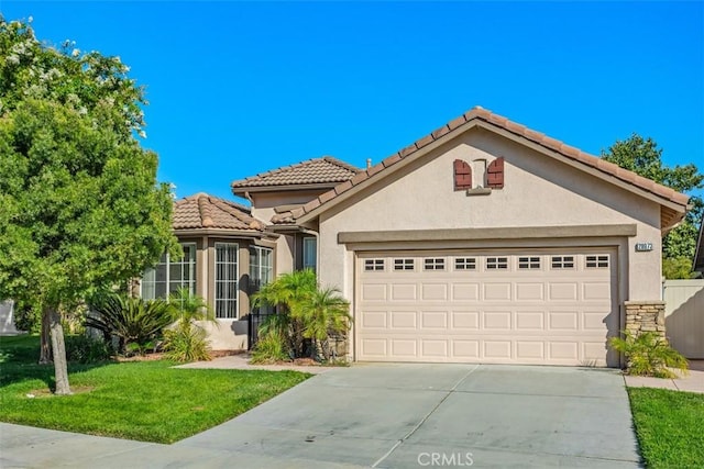 mediterranean / spanish-style home with a garage and a front lawn