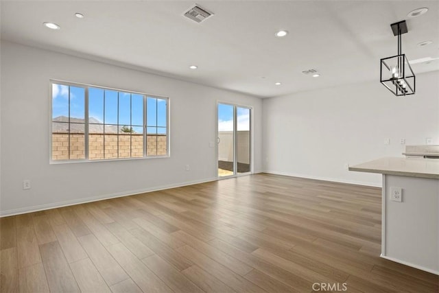 unfurnished living room with wood-type flooring and plenty of natural light