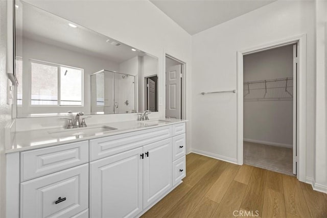 bathroom featuring hardwood / wood-style floors, vanity, and a shower with shower door