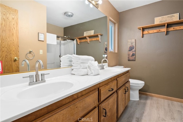 bathroom featuring wood-type flooring, walk in shower, vanity, and toilet