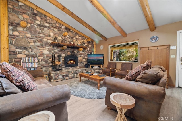 living room with light hardwood / wood-style floors, a fireplace, and lofted ceiling with beams