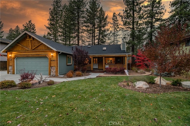 view of front of house with a yard, covered porch, and a garage