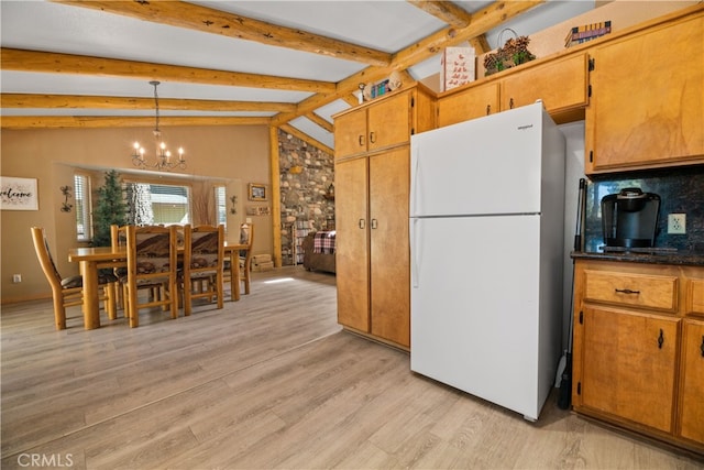 kitchen featuring lofted ceiling with beams, pendant lighting, white fridge, light hardwood / wood-style flooring, and a chandelier