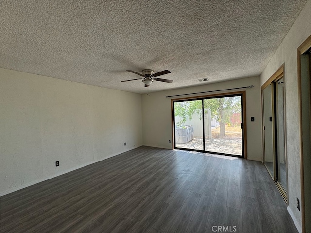 empty room featuring ceiling fan, a textured ceiling, and dark hardwood / wood-style floors