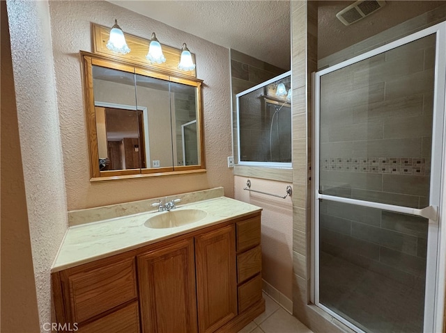 bathroom featuring a textured ceiling, vanity, tile patterned floors, and an enclosed shower