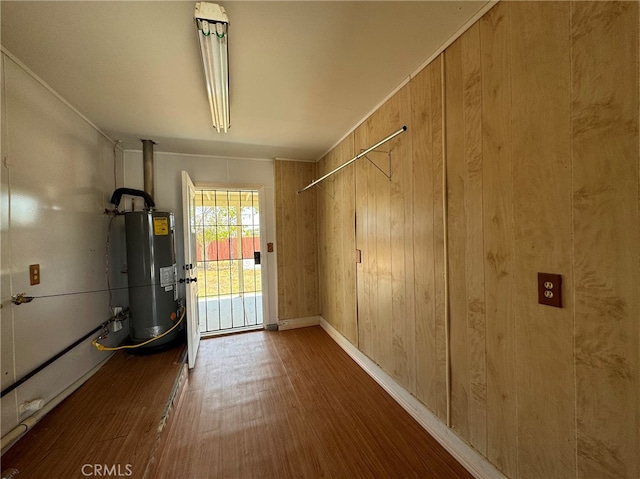 interior space with gas water heater and wood walls