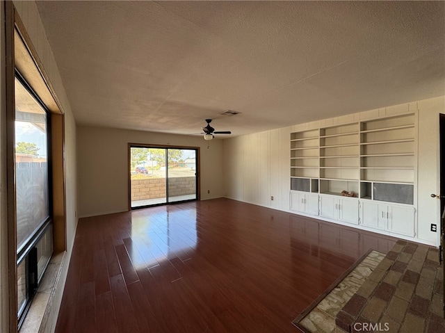 empty room featuring a textured ceiling, dark hardwood / wood-style flooring, and ceiling fan