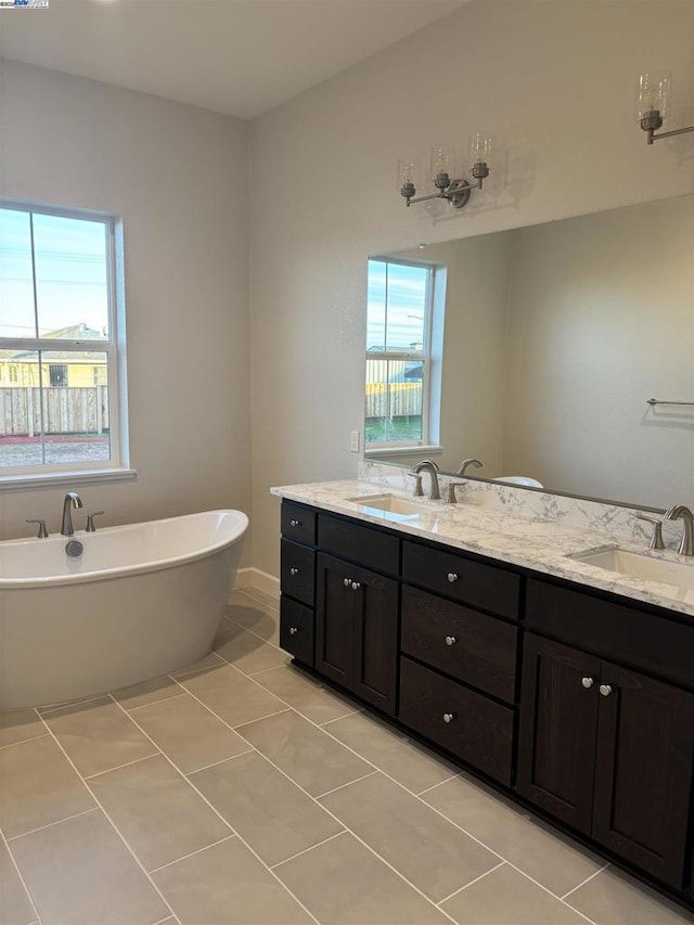 bathroom featuring tile patterned flooring, vanity, and a washtub