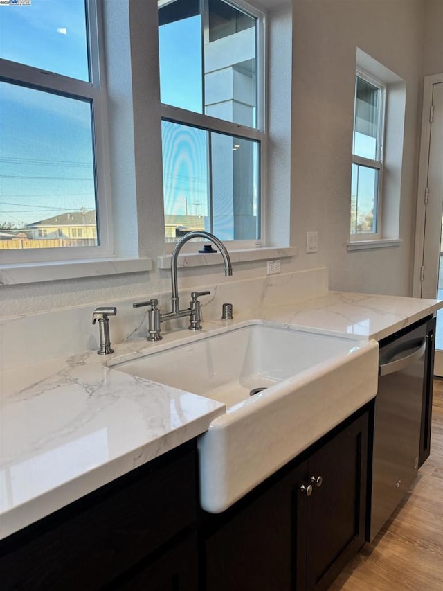 kitchen featuring a healthy amount of sunlight, dishwasher, and light stone countertops