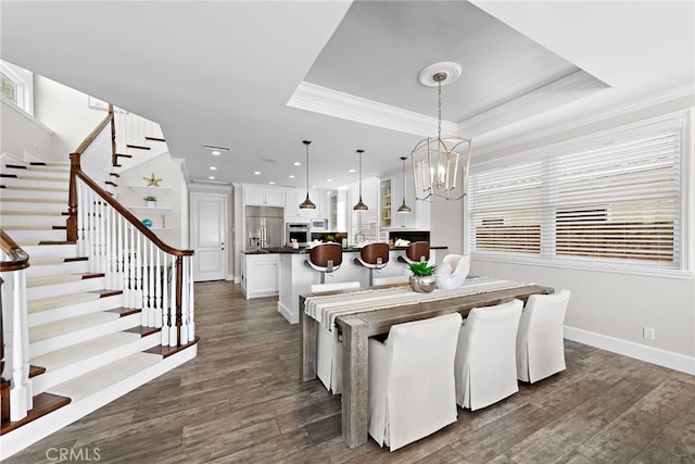 dining area with crown molding, dark hardwood / wood-style floors, a wealth of natural light, and a tray ceiling