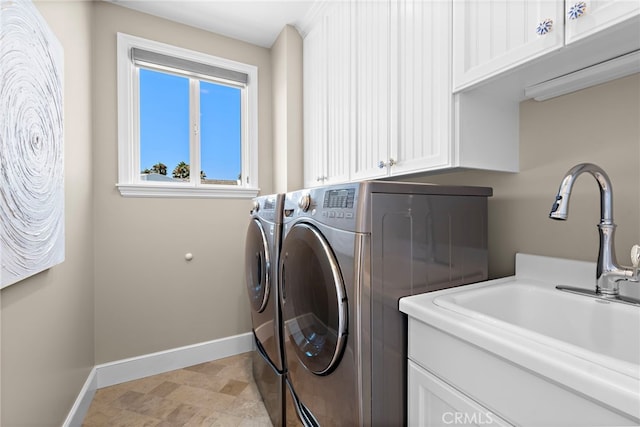 washroom with cabinets, sink, and washing machine and clothes dryer