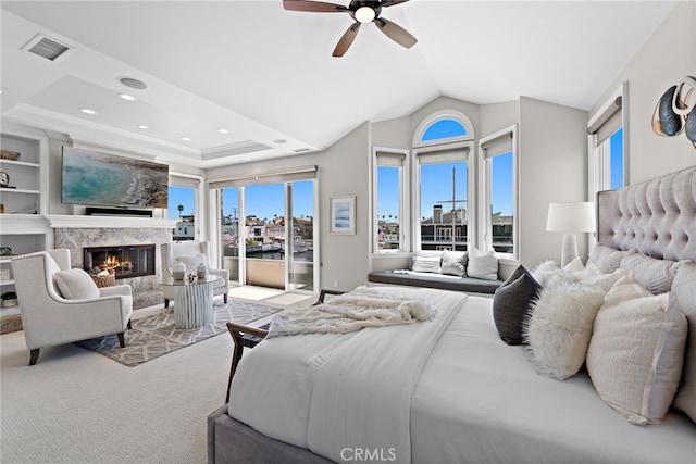 bedroom with ceiling fan, light carpet, a premium fireplace, and a raised ceiling