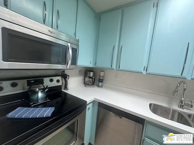 kitchen featuring stainless steel appliances, sink, and tasteful backsplash