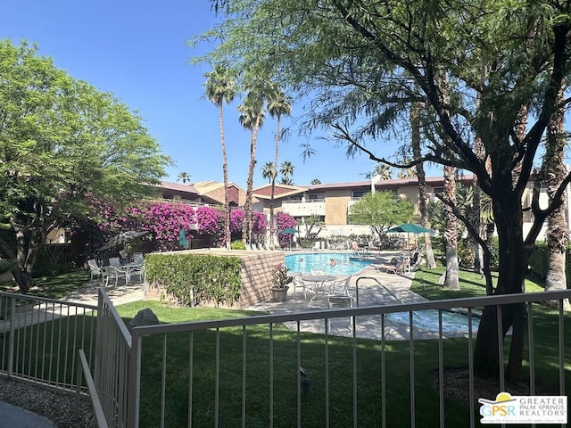 view of swimming pool featuring a patio and a yard