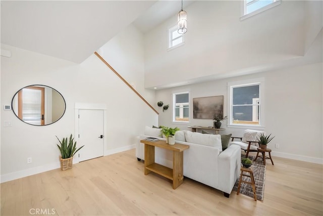 living room with a towering ceiling and light hardwood / wood-style floors