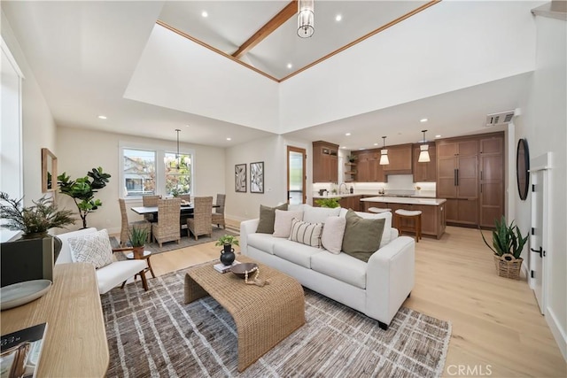 living room with light hardwood / wood-style floors and a high ceiling