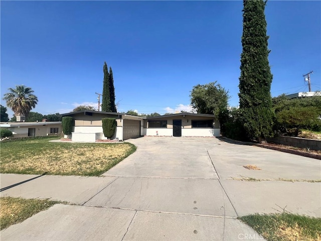 single story home featuring a front yard and a garage