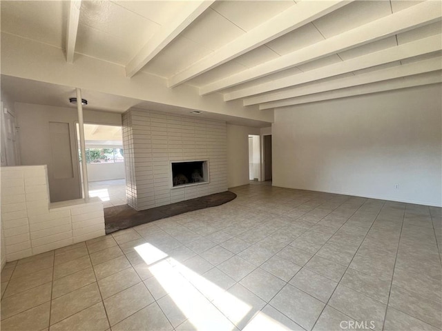 unfurnished living room featuring beam ceiling, light tile patterned floors, and a fireplace