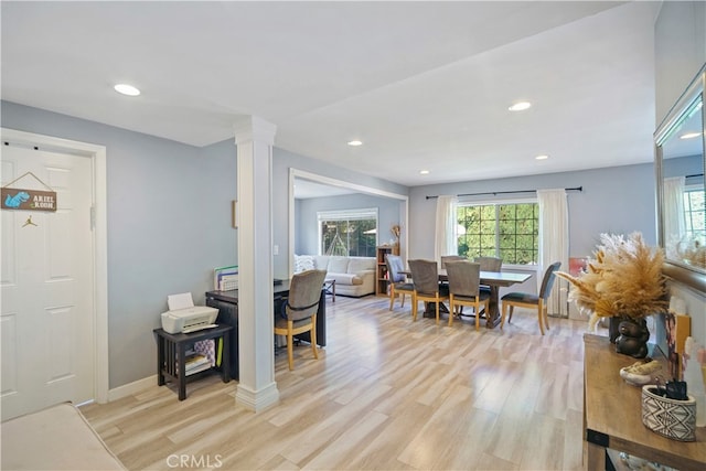 living room with light hardwood / wood-style flooring and decorative columns