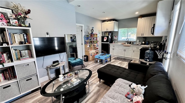 living room with light hardwood / wood-style flooring and sink