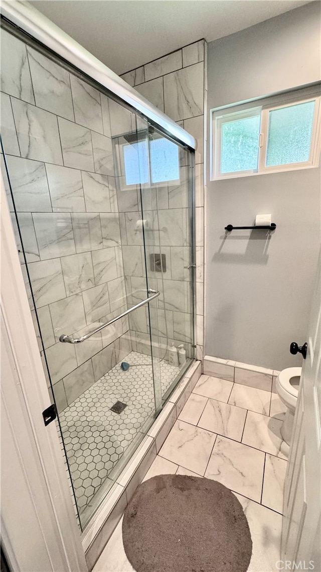 bathroom with walk in shower and toilet