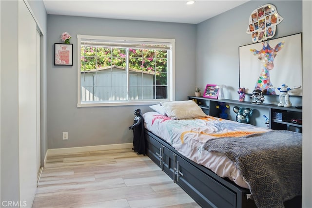 bedroom with light wood-type flooring and a closet