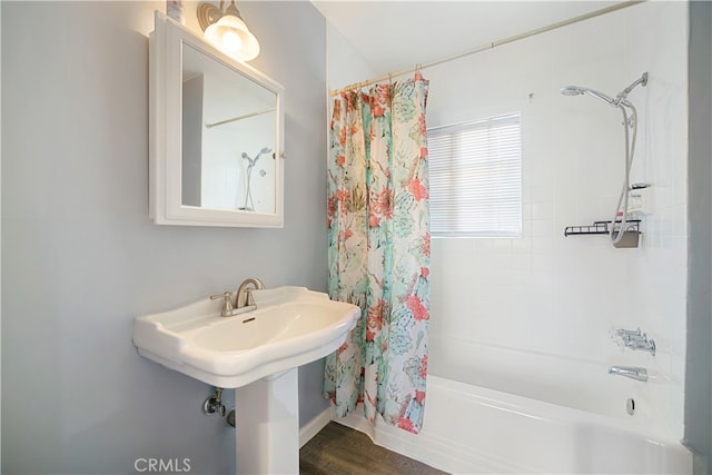 bathroom with hardwood / wood-style flooring and shower / bath combination with curtain