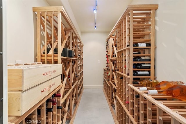 wine area featuring concrete flooring and track lighting