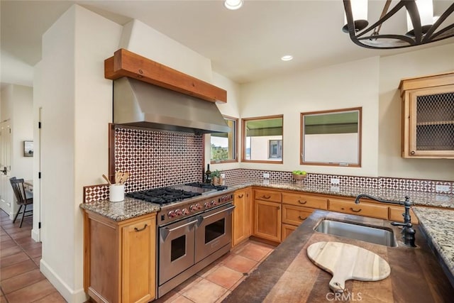 kitchen with sink, backsplash, a chandelier, double oven range, and extractor fan