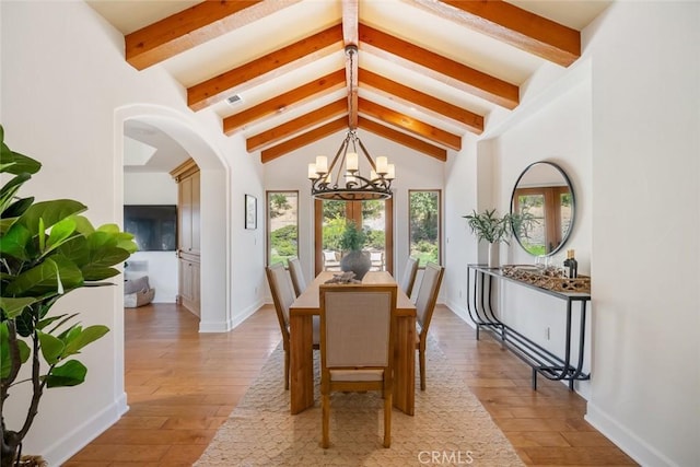 dining area featuring hardwood / wood-style floors, a notable chandelier, and lofted ceiling with beams