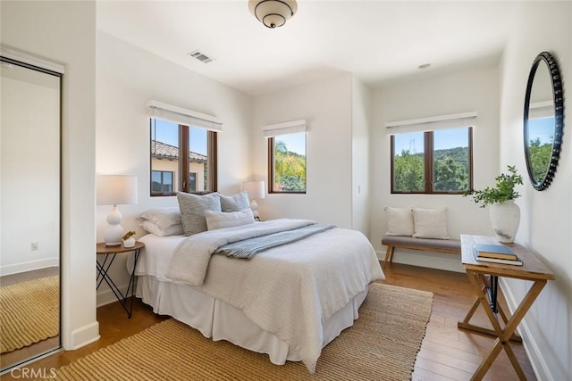 bedroom featuring multiple windows and hardwood / wood-style flooring