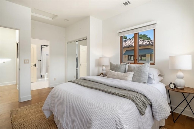 bedroom with hardwood / wood-style floors and a closet