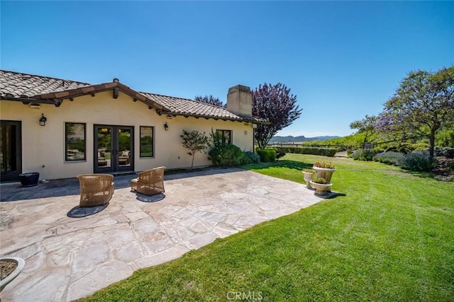 back of property featuring french doors, a patio, and a yard